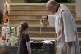 Priester bereitet das Taufbecken für bevorstehende Taufe vor